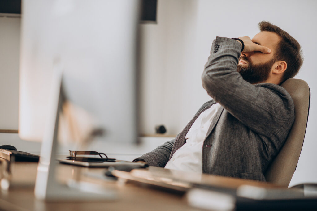 uomo in ufficio, stanchezza da stress per rientro ferie
